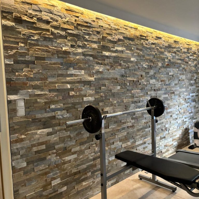 Ein Arbeitsbereich mit hellem Stein und einem Kupferwasserhahn an der Wand.